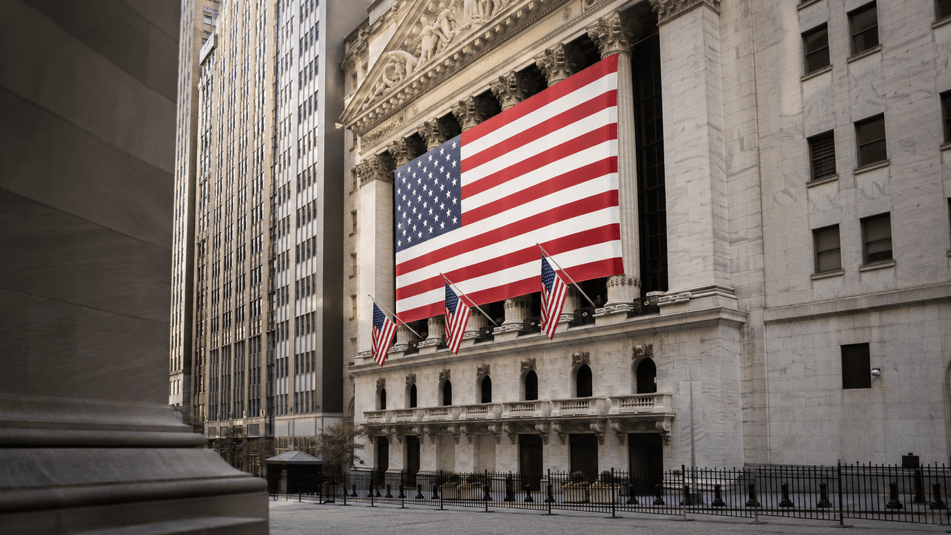 واجهة بورصة نيويورك (NYSE) في وول ستريت بأعمدتها الرخاميّة وقد كُسيت بعلمٍ أمريكيّ كبير، والمكان هادئ ومغلق في عطلة جونتينث